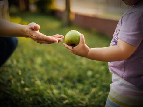 la bambina dona una mela alla mamma